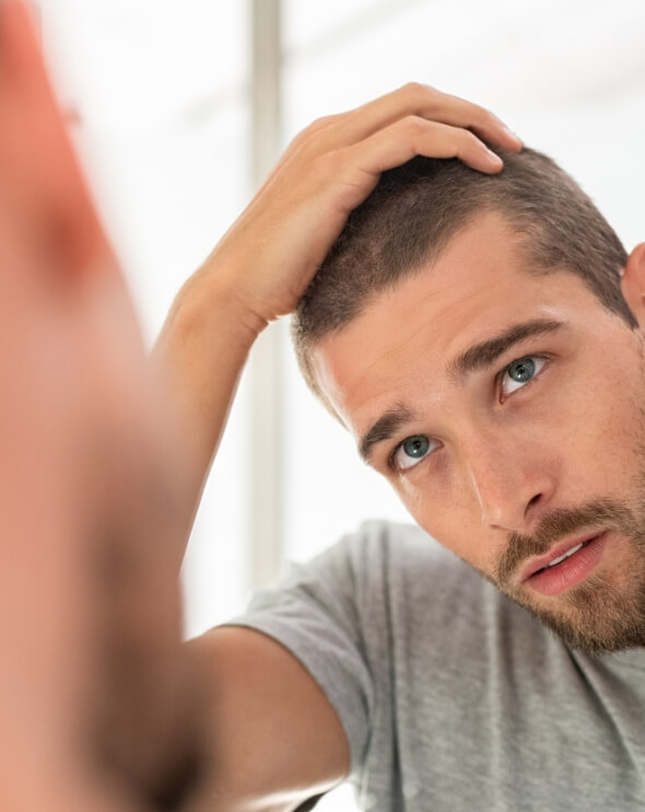 young-man-checking-hair-in-mirror-2021-08-26-15-34-43-utc